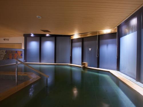 an empty swimming pool in a building with a pool at Kyoto Hot Spring Hatoya Zuihokaku Hotel in Kyoto