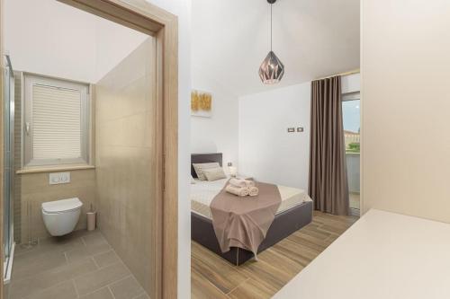 une salle de bain avec un lit et des toilettes dans une chambre dans l'établissement Villa VoriC by IstriaLux, à Svetvinčenat
