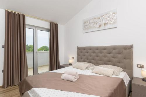 een slaapkamer met een groot bed en een groot raam bij Villa VoriC by IstriaLux in Svetvinčenat