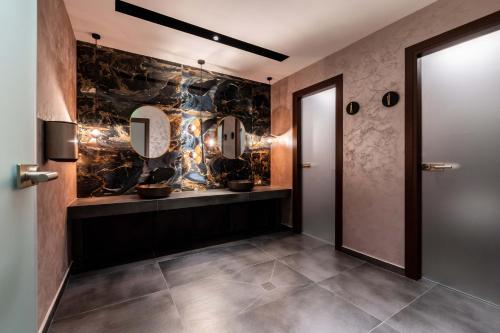 a hallway with a bathroom with a mirror at Mirabilis Boutique Hotel by Panel Hospitality in Kalabaka