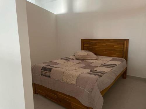 een slaapkamer met een bed in een witte kamer bij Chez Romuas in Le Tampon