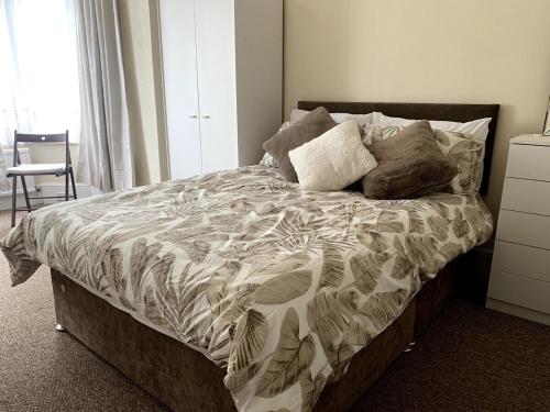 a bedroom with a large bed with a comforter at SILVERDALE HOUSE in Southend-on-Sea