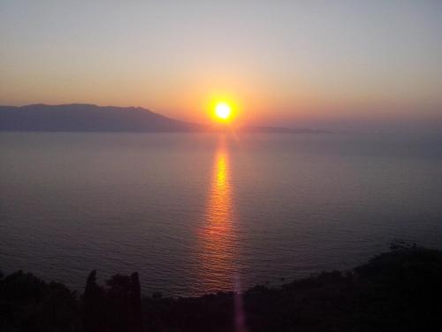 a sunset over the water with the sun in the sky at Seaview Studio in beautiful setting west from Chania in Ravdhoúkha