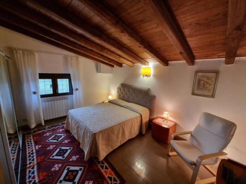 ein Schlafzimmer mit einem Bett und einem Stuhl in der Unterkunft Country house Dolce Nocciola in Vignanello