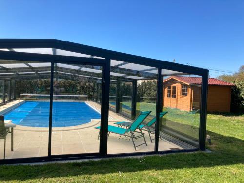 - un pavillon avec une piscine et une chaise dans la cour dans l'établissement Chambre d'Hôtes LES ROCHES, à Corme-Royal