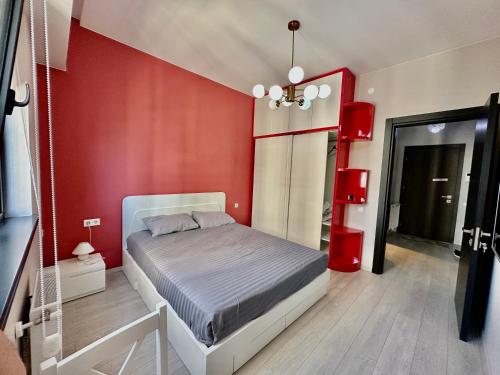 DavidL Studio in Kazbegi avenue في تبليسي: غرفة نوم بسرير في جدار احمر