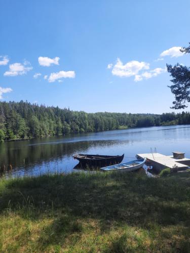 two boats sitting on the shore of a lake at Hemtrevlig villa i Billingsfors in Billingsfors