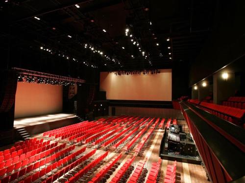 an empty auditorium with red seats and a stage at Shinagawa Prince Hotel in Tokyo