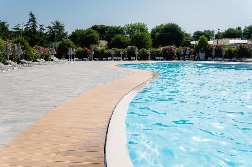 uma piscina com água azul e cadeiras em Glamping Istrië em Fasana