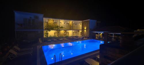 a large swimming pool in front of a building at night at Hotel Nereides in Patitiri