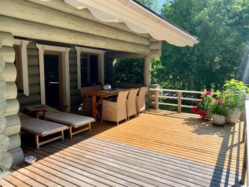 a wooden deck with chairs and a table at Kasepuu Holiday House in Uulu