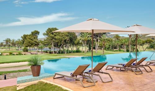 a group of chairs and umbrellas next to a pool at Grand Hyatt La Manga Club Golf & Spa in La Manga del Mar Menor