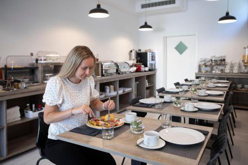 a woman sitting at a table with a plate of food at Boutique Hotel Intermezzo - Pag centre in Pag