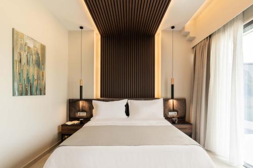 a bedroom with a large white bed and a window at Mirabilis Boutique Hotel by Panel Hospitality in Kalabaka