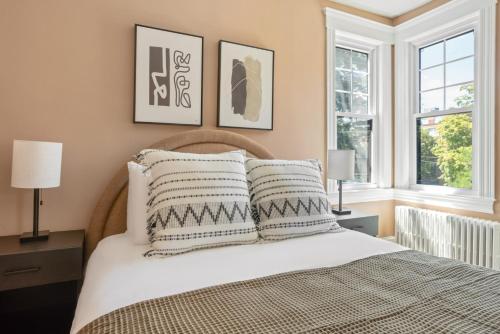 a bedroom with a large bed with two windows at Bright Brighton 1BR near T Shops BOS-775 in Boston