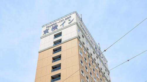 Un palazzo alto con un orologio sopra. di Toyoko Inn Gumma Ota eki Minami guchi a Ota