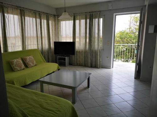 a living room with a green couch and a coffee table at Apartments Jasu in Kivérion