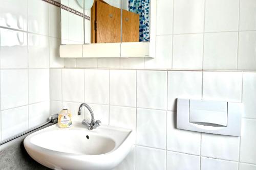 a white bathroom with a sink and a mirror at Apartment with balcony in Lennestadt