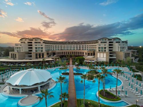 uma vista para um resort com uma piscina e palmeiras em Kaya Palazzo Golf Resort em Belek