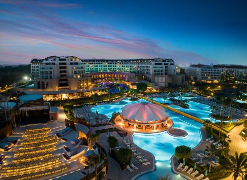 een resort met een groot zwembad in de nacht bij Kaya Palazzo Golf Resort in Belek