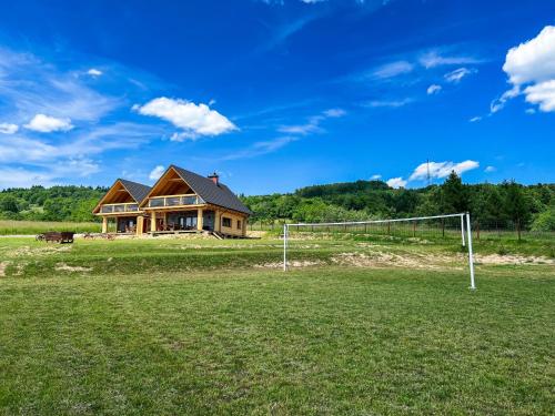 a house on a field with a soccer goal at Wood Szczęścia in Korczyna