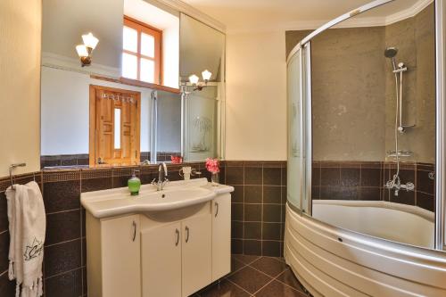 La salle de bains est pourvue d'un lavabo, d'une baignoire et d'une douche. dans l'établissement Çınarlar Apart KC Blok, à Kaş