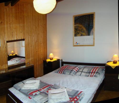 sypialnia z łóżkiem i dużym lustrem w obiekcie Apartments Maroflin w mieście Crni Lug
