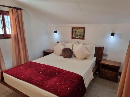 a bedroom with a large white bed with pillows at The Drake Seaside Apartment in Bel Ombre