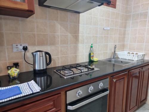 a kitchen with a stove top oven next to a sink at The Drake Seaside Apartment in Bel Ombre