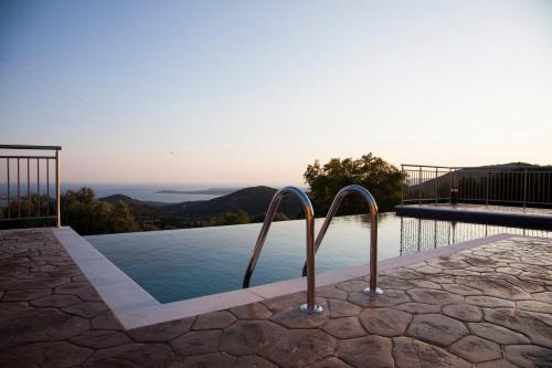 a swimming pool with a view of the mountains at Villa Anthodesmi in Dilináta