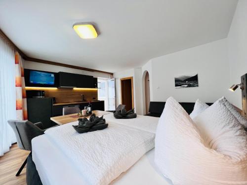 a bedroom with two white beds and a dining room at Appart Kofler in Gerlos