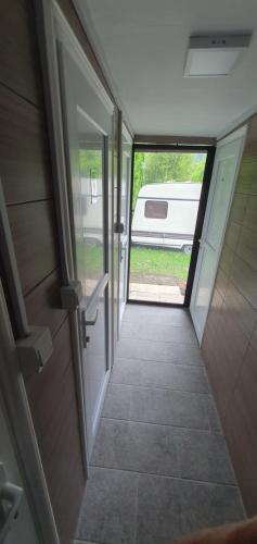 einen Flur, der zu einer offenen Tür eines Wohnmobils führt in der Unterkunft Kamp kućica trokrevetna in Crnča