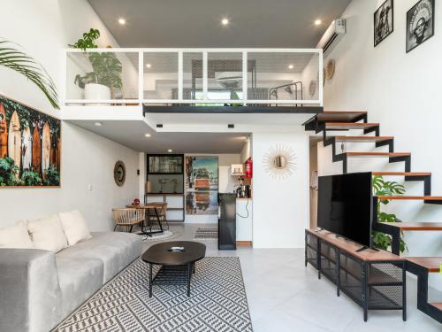 ein Wohnzimmer mit einer Couch und einer Treppe in der Unterkunft Tropicana Loft Canggu in Canggu