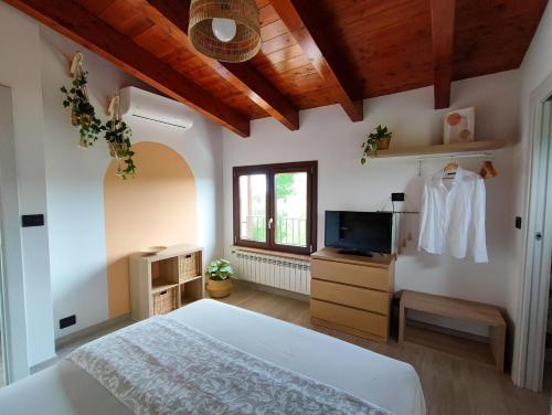 a bedroom with a white bed and a tv at Desideria Rooms Bed and Breakfast in Torino di Sangro