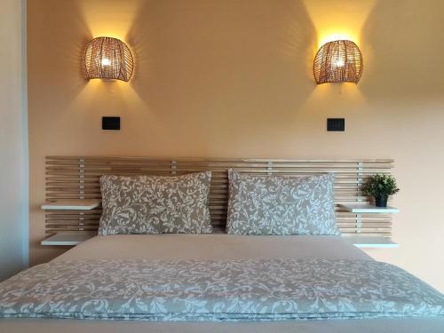a bedroom with a bed with two lights on the wall at Desideria Rooms Bed and Breakfast in Torino di Sangro