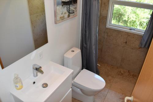 ein Badezimmer mit einem WC, einem Waschbecken und einem Spiegel in der Unterkunft Holiday home with panoramic ocean view near Kerteminde in Martofte