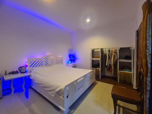 a bedroom with a bed and a desk with a purple light at House by the sea in Haad Tian