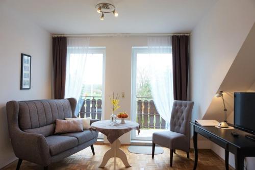 a living room with a couch and a chair and a television at Pension Tüxen in Hasselberg