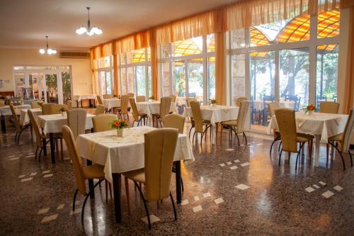 a dining room with tables and chairs and windows at ADIS Holiday Inn Hotel in Golden Sands