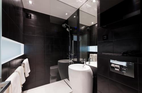 a black bathroom with a toilet and a sink at Unique Rooms in Zadar