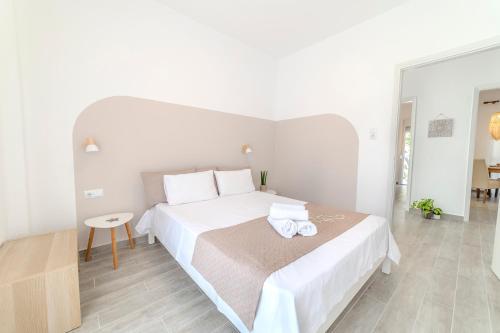 um quarto branco com uma cama grande e uma mesa em Stamatia Suites em Asprovalta