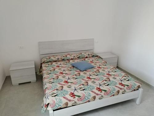 ein Schlafzimmer mit einem Bett mit einer Bettdecke mit Blumen in der Unterkunft Villa Chiara in Marina di Sorso