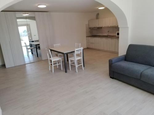 ein Wohnzimmer mit einem Sofa, einem Tisch und Stühlen in der Unterkunft Villa Chiara in Marina di Sorso
