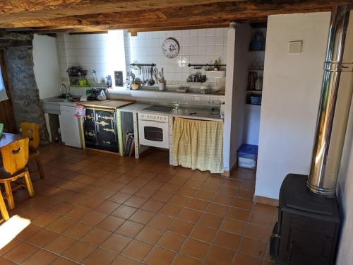 cocina con electrodomésticos blancos y suelo de baldosa. en Casa La Parra, en Villar de Vildas