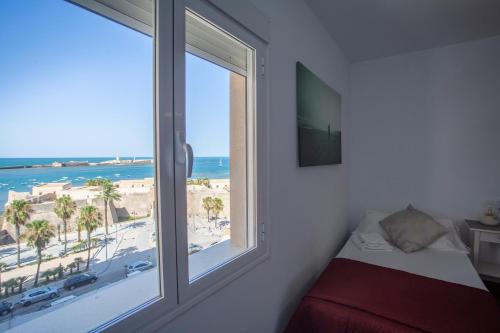 加的斯的住宿－OCEANO Family Home free parking by Cadiz4Rentals，一间卧室设有窗户,享有海滩美景