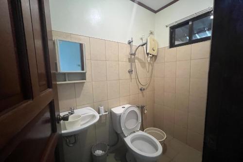 een badkamer met een toilet en een wastafel bij Tenzai Homestay in Puerto Princesa City