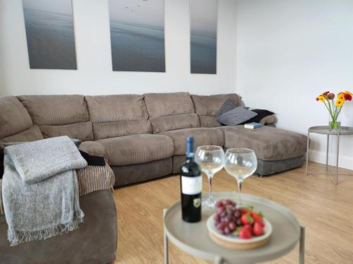 a living room with a couch and a table with wine glasses at Portrush by the Sea - 2 Dunluce Green in Portrush