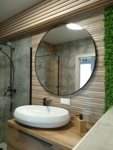 a bathroom with a white sink and a mirror at Apartament Sądecki in Nowy Sącz