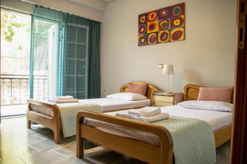 1 Schlafzimmer mit 2 Betten und einem Fenster in der Unterkunft Paradise residency in Nea Iraklitsa
