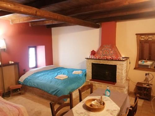 1 dormitorio con 1 cama y chimenea en Yono's Traditional House, en Áno Ravénia